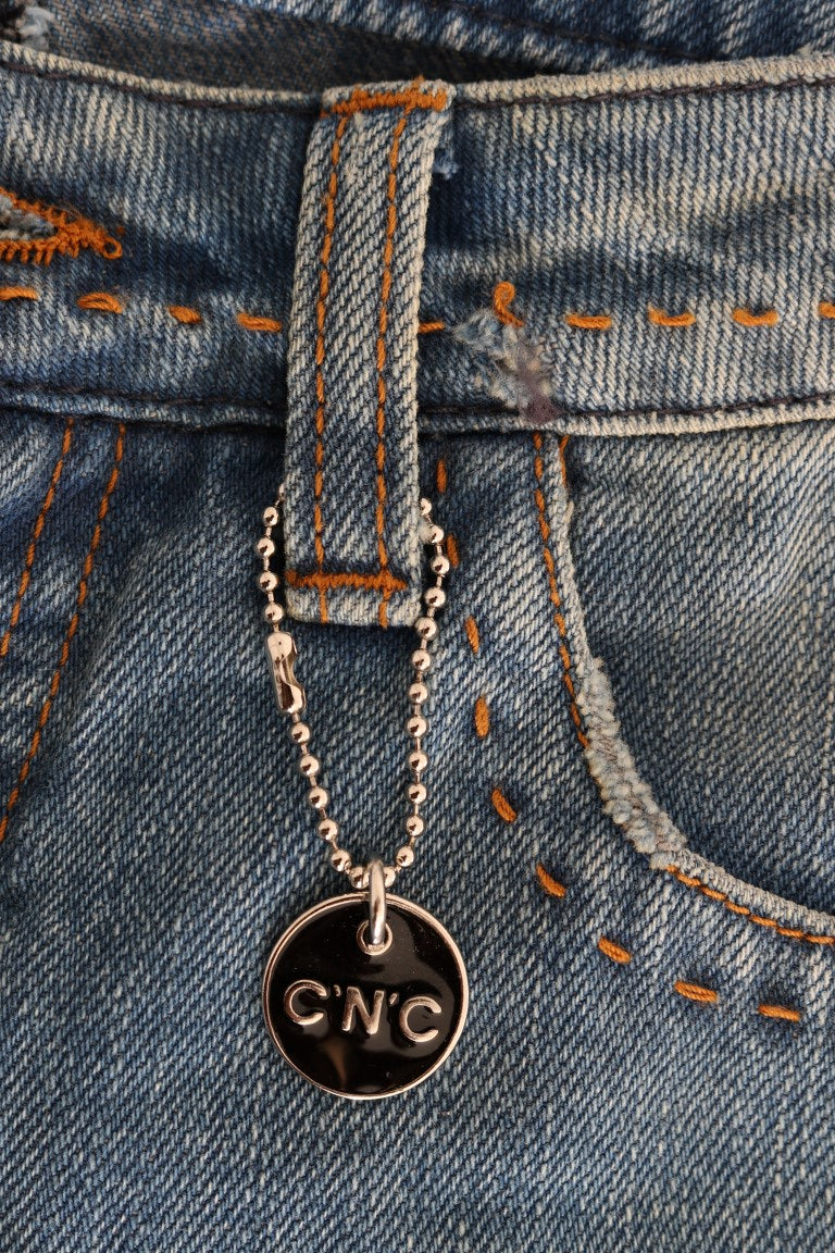 Silver necklace with a cross pendant on blue jeans