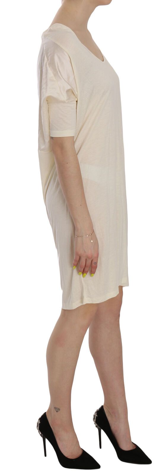 A knee length dress with a round neckline, cream color, and visible detailing on the bodice