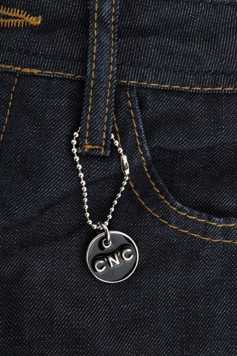 Silver necklace with black pendant hanging from jeans pocket
