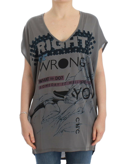 Woman wearing a gray shirt with colorful writing and graphics