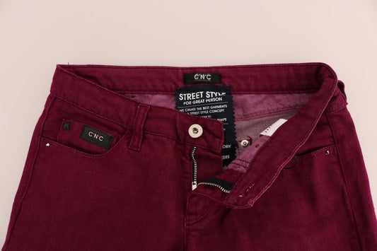 Pair of dark red jeans on hanger