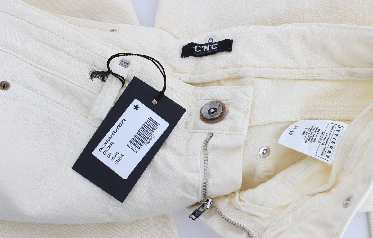 Pair of light yellow jeans with black tag attached to waistband