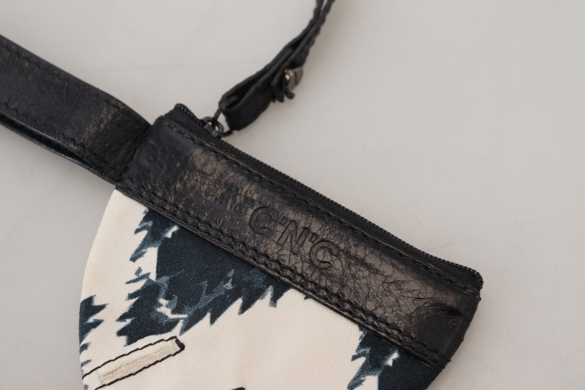 Black leather crossbody bag with a patterned fabric panel