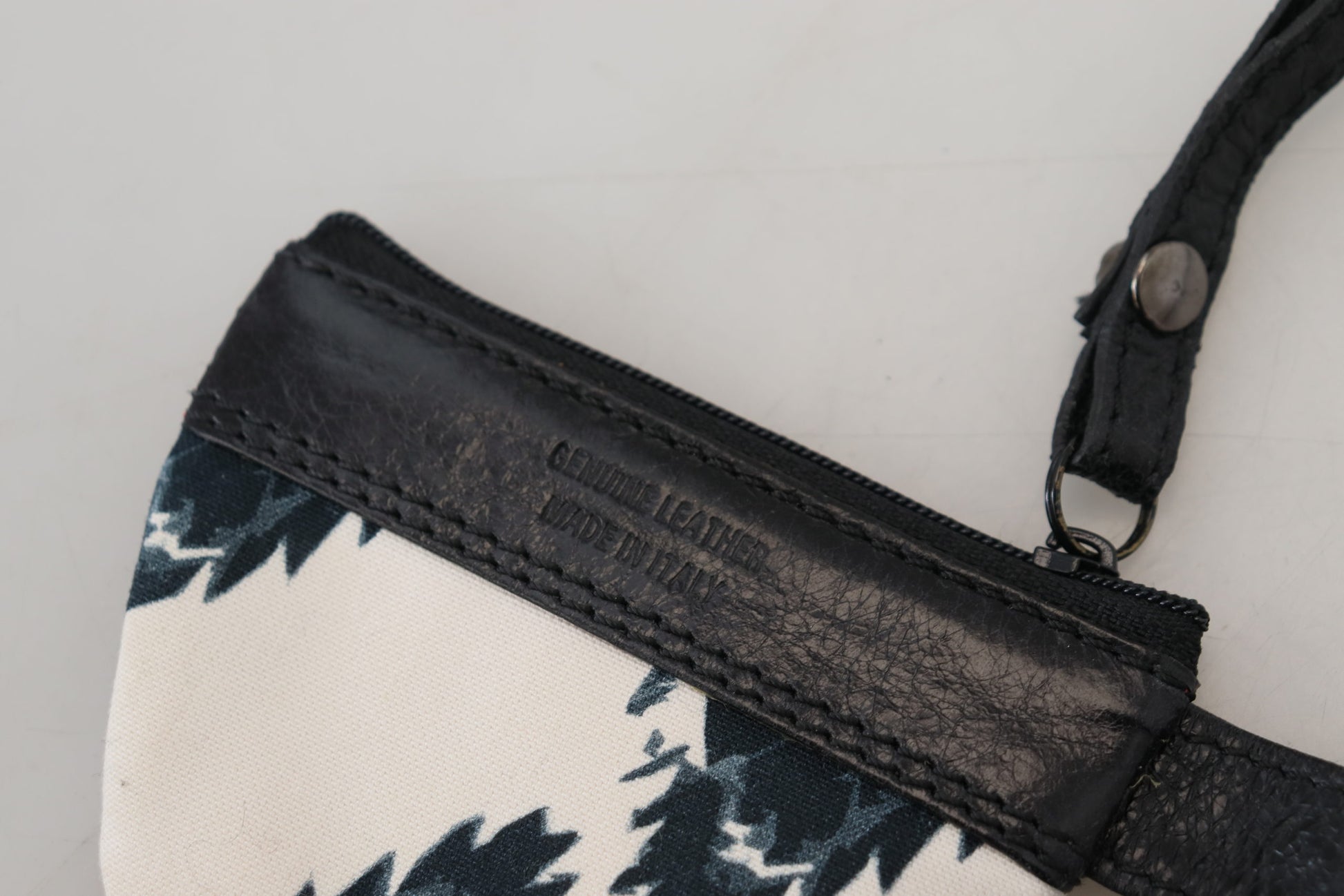 Black leather crossbody bag with a floral patterned fabric panel