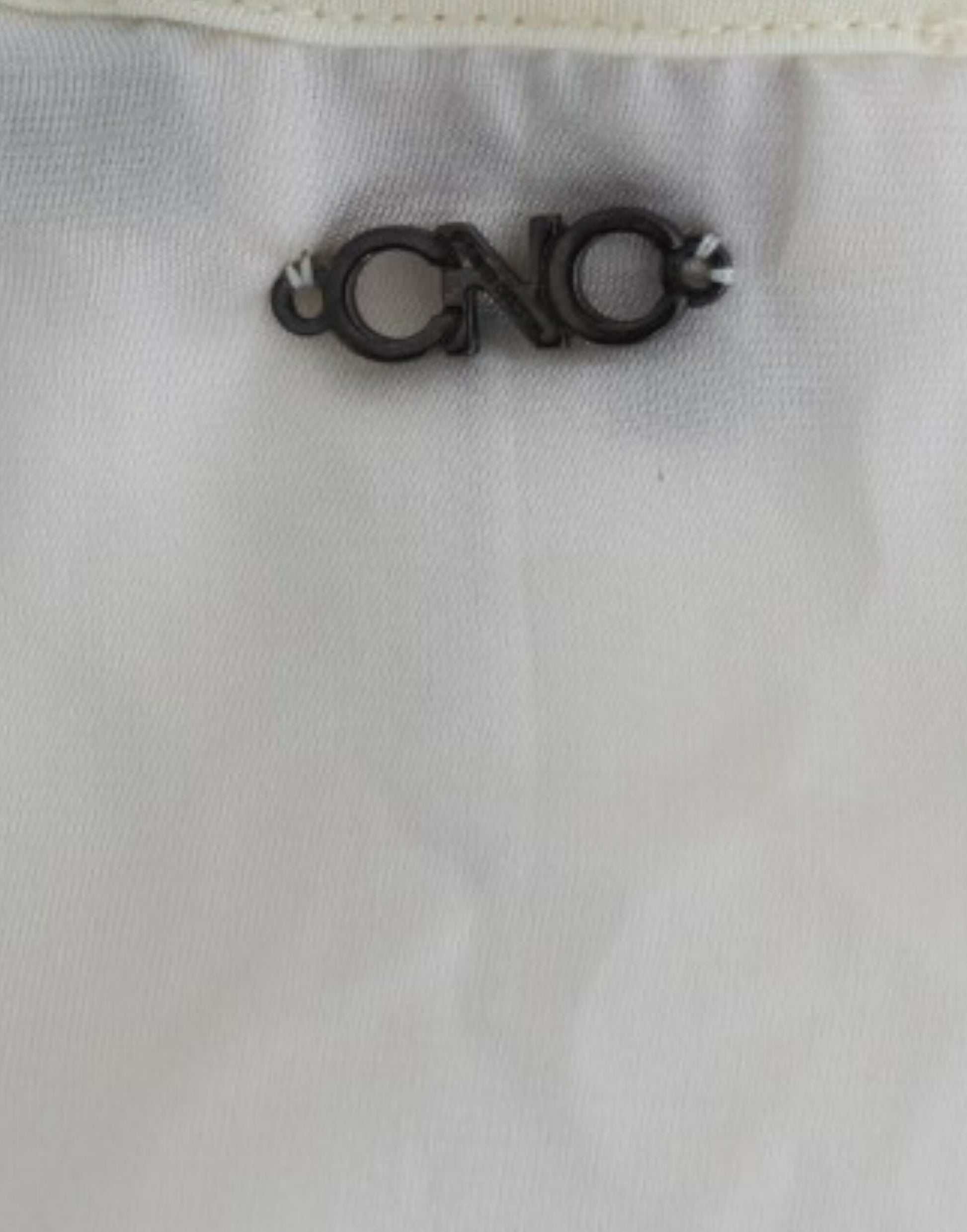 Black metal clothing label with white letters