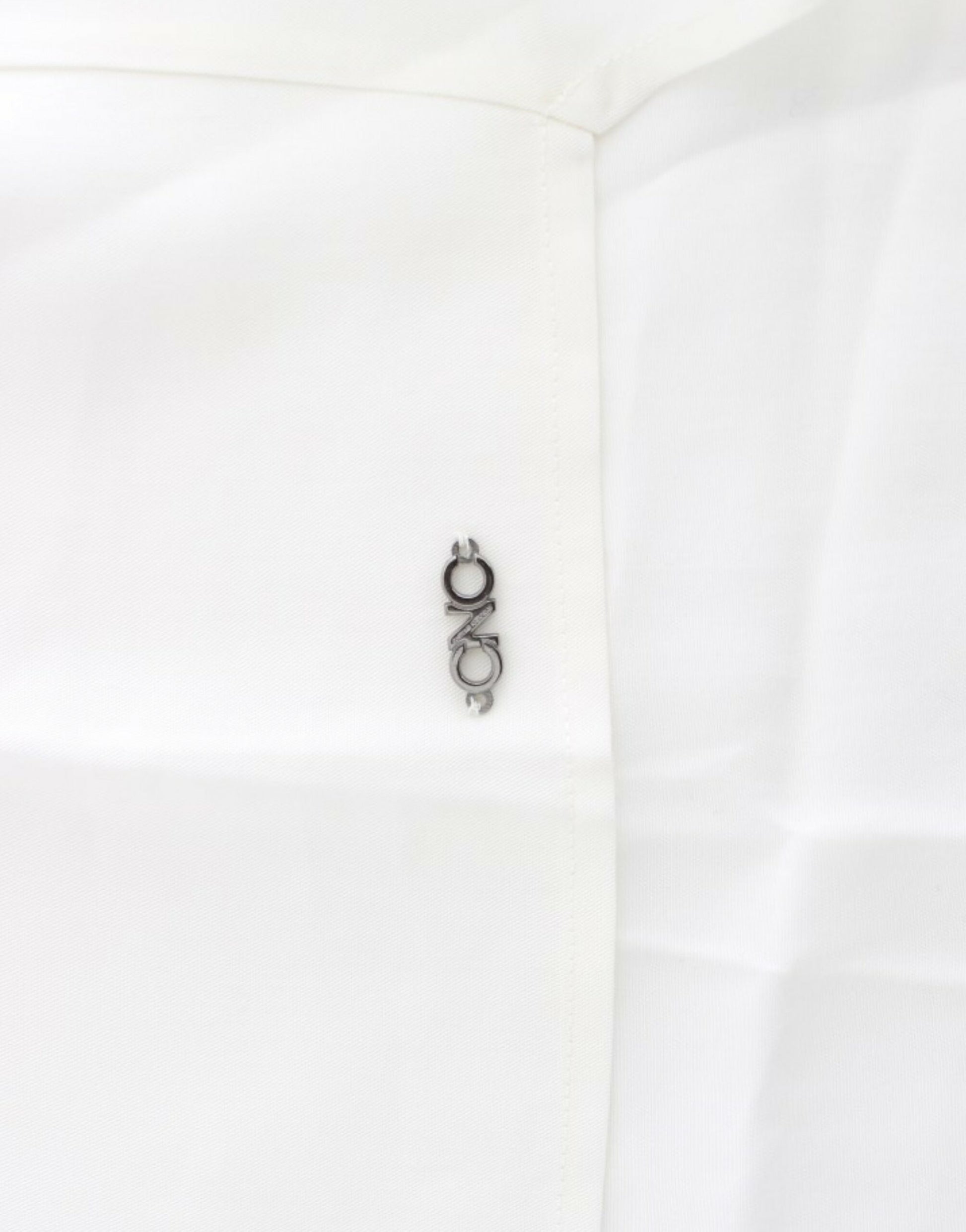 Small silver pin on white fabric