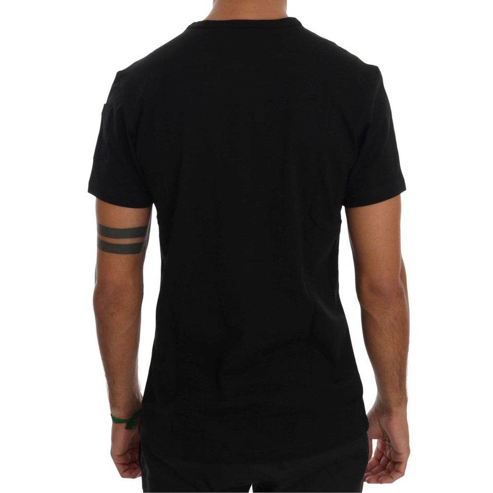 A black cotton t-shirt with short sleeves, worn by a person standing against a white background