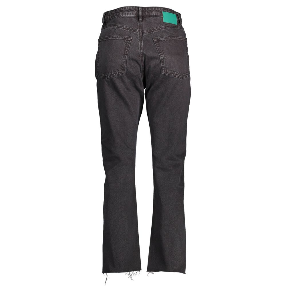 Pair of dark blue jeans with a green tag on the waistband