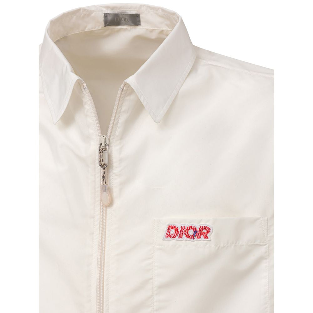 A white polyester shirt with a zippered front, short sleeves and a logo on the left chest