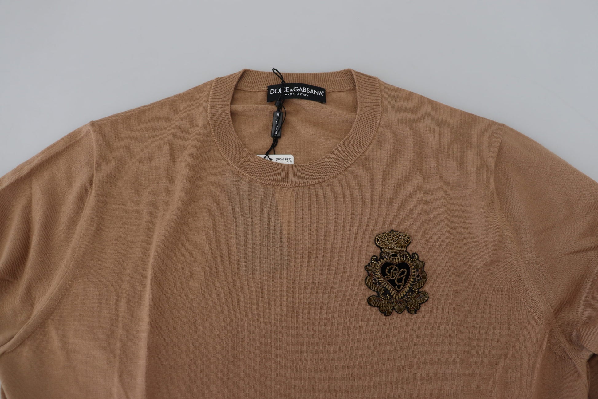Brown sweater with emblem on front
