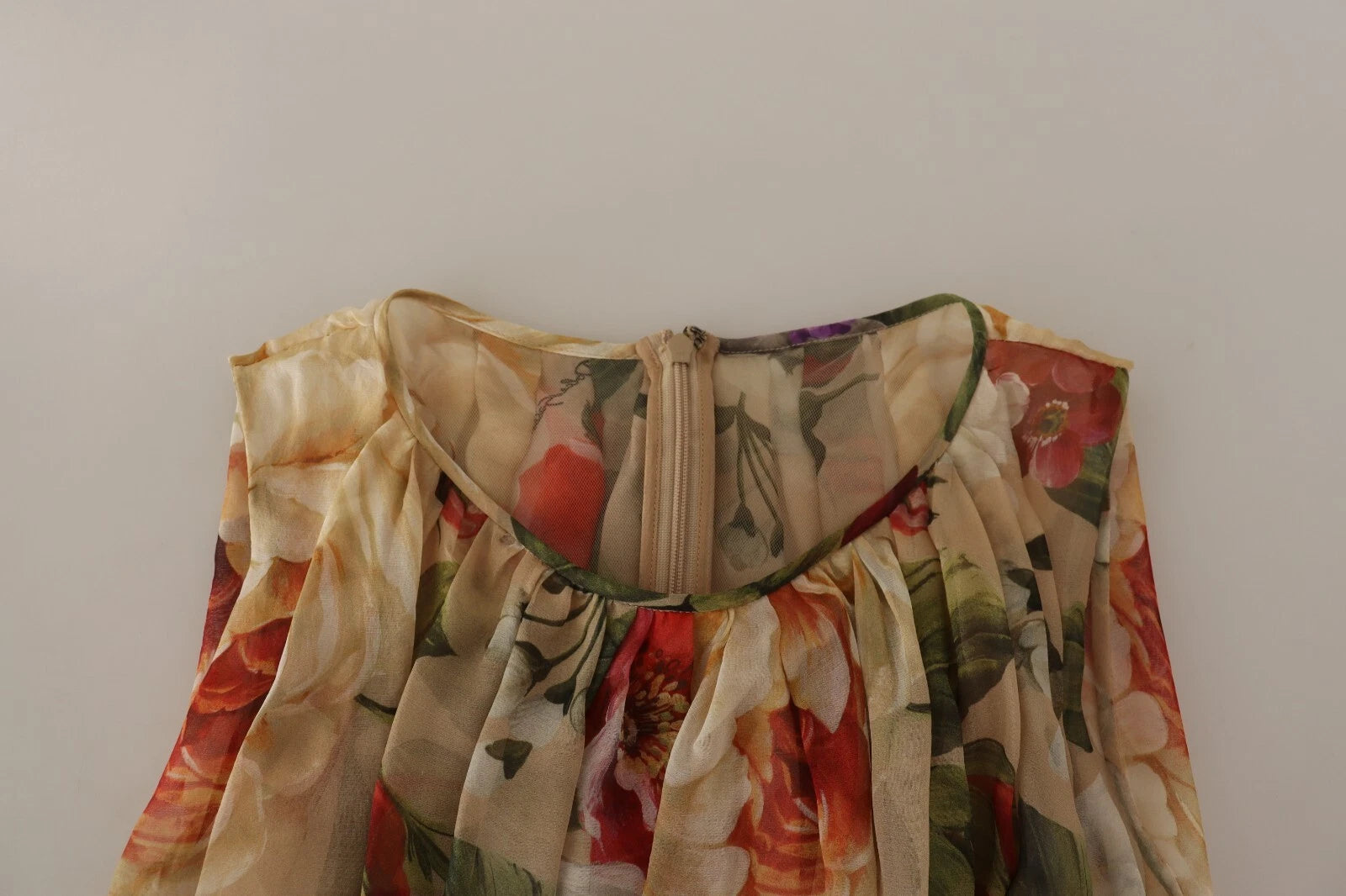 This is a beige floral sleeveless dress with an A-line silhouette
