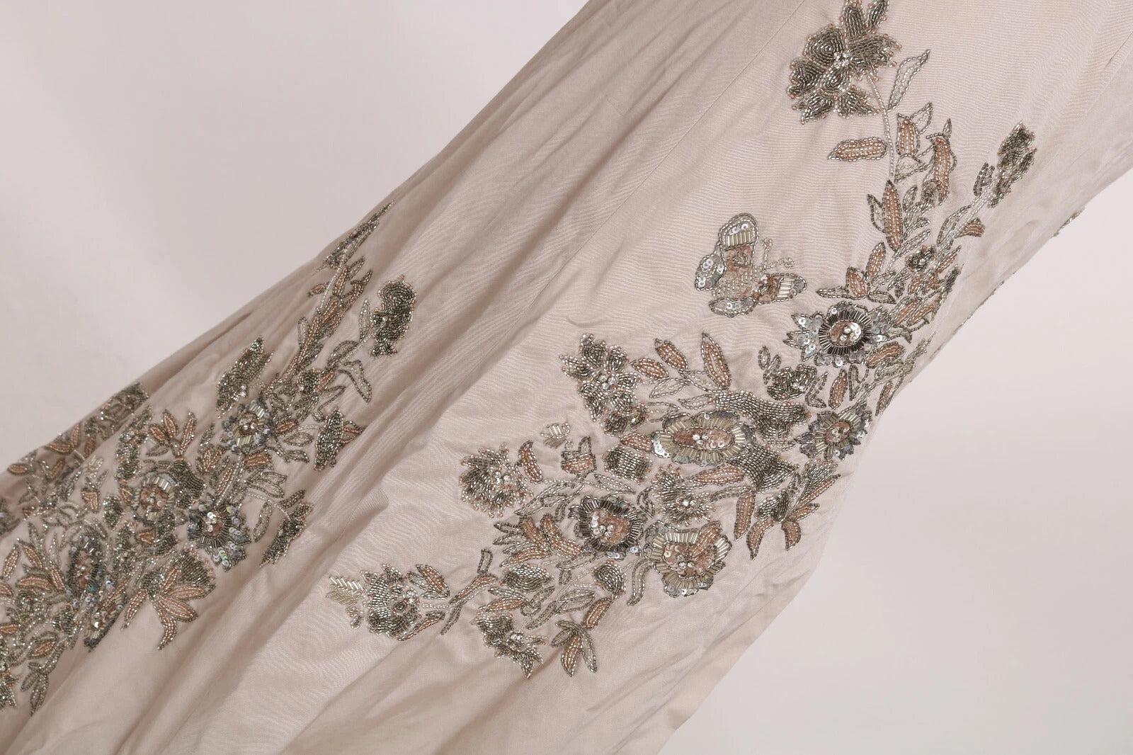 A beige sequined dress with floral embroidery and a flared skirt