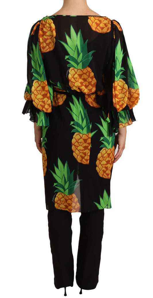 A black dress with a print of pineapples and leaves
