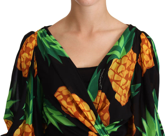 A black dress with a print of yellow pineapples and green leaves