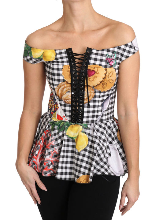 Woman wearing a black and white checkered top with fruit and floral patterns