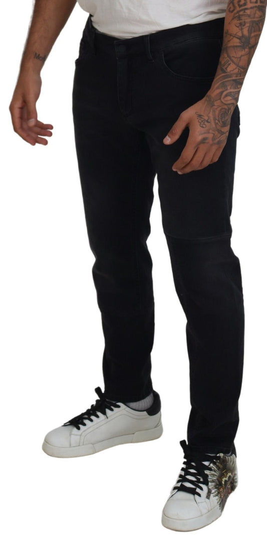 Man wearing black pants, white shirt, tattoos on arms, sneakers