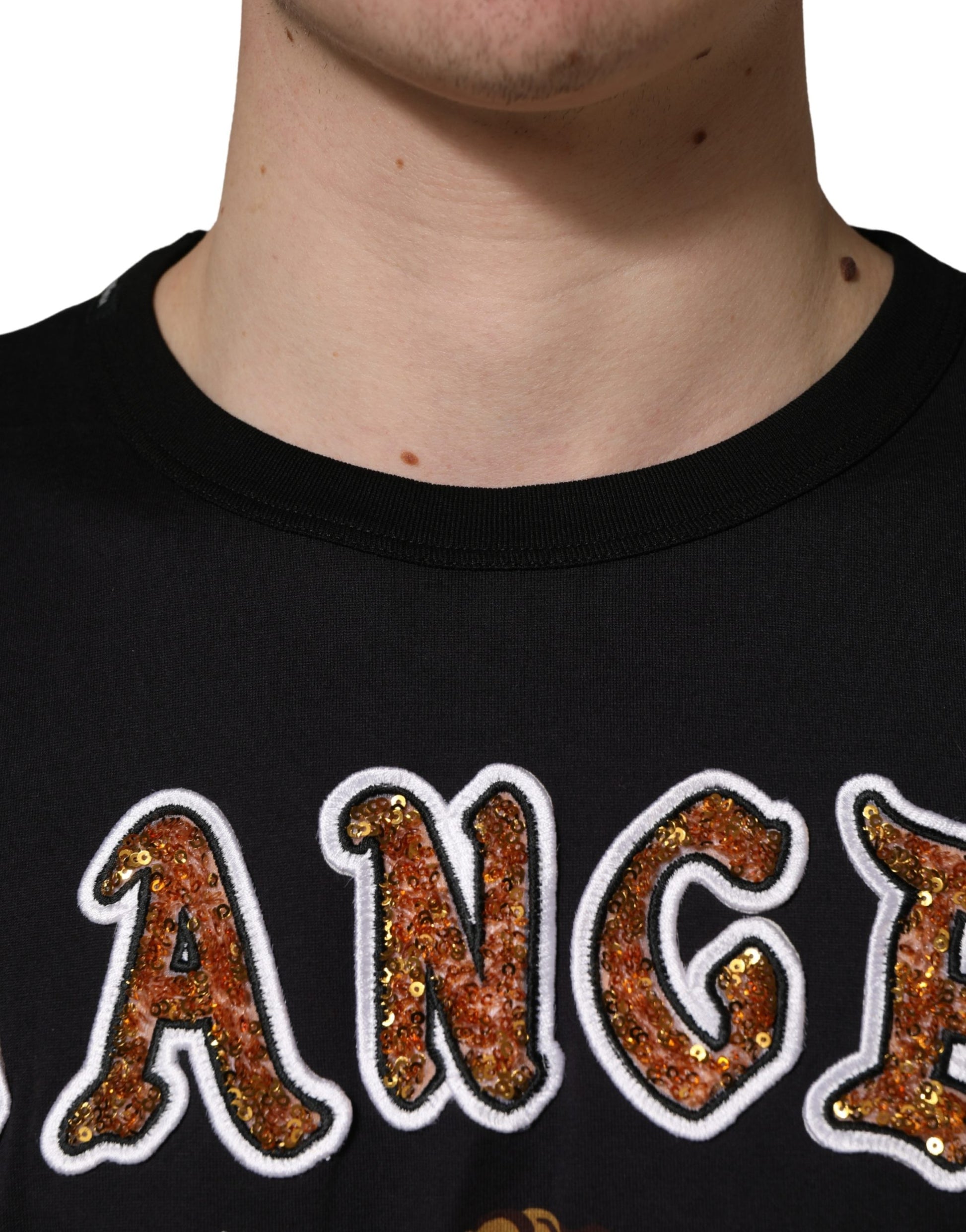 A black crew neck t-shirt with an angel print and gold sequins on the front