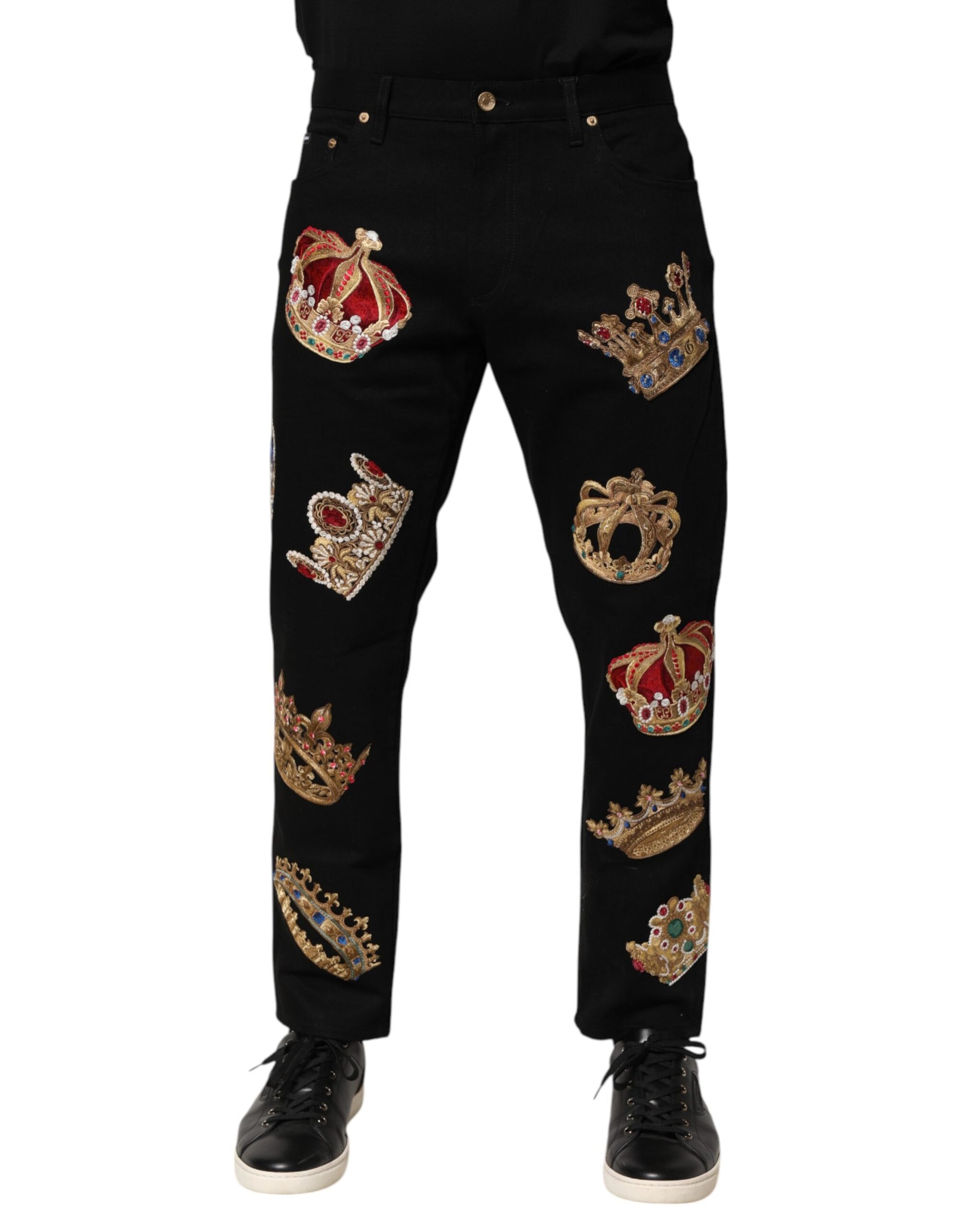 A pair of black trousers with embroidered crowns and other royal motifs