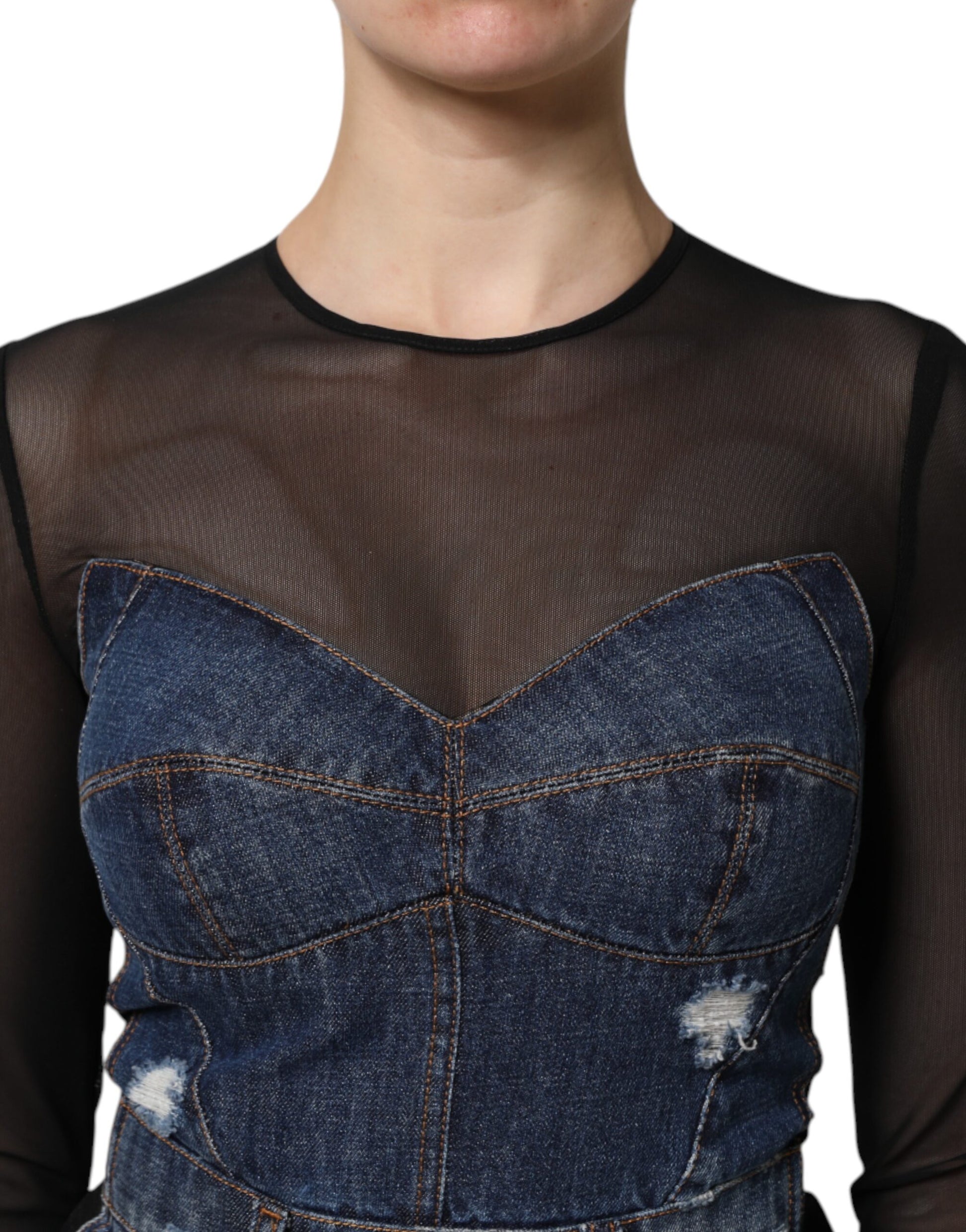 A woman wearing a black denim dress with long sleeves and a high neckline