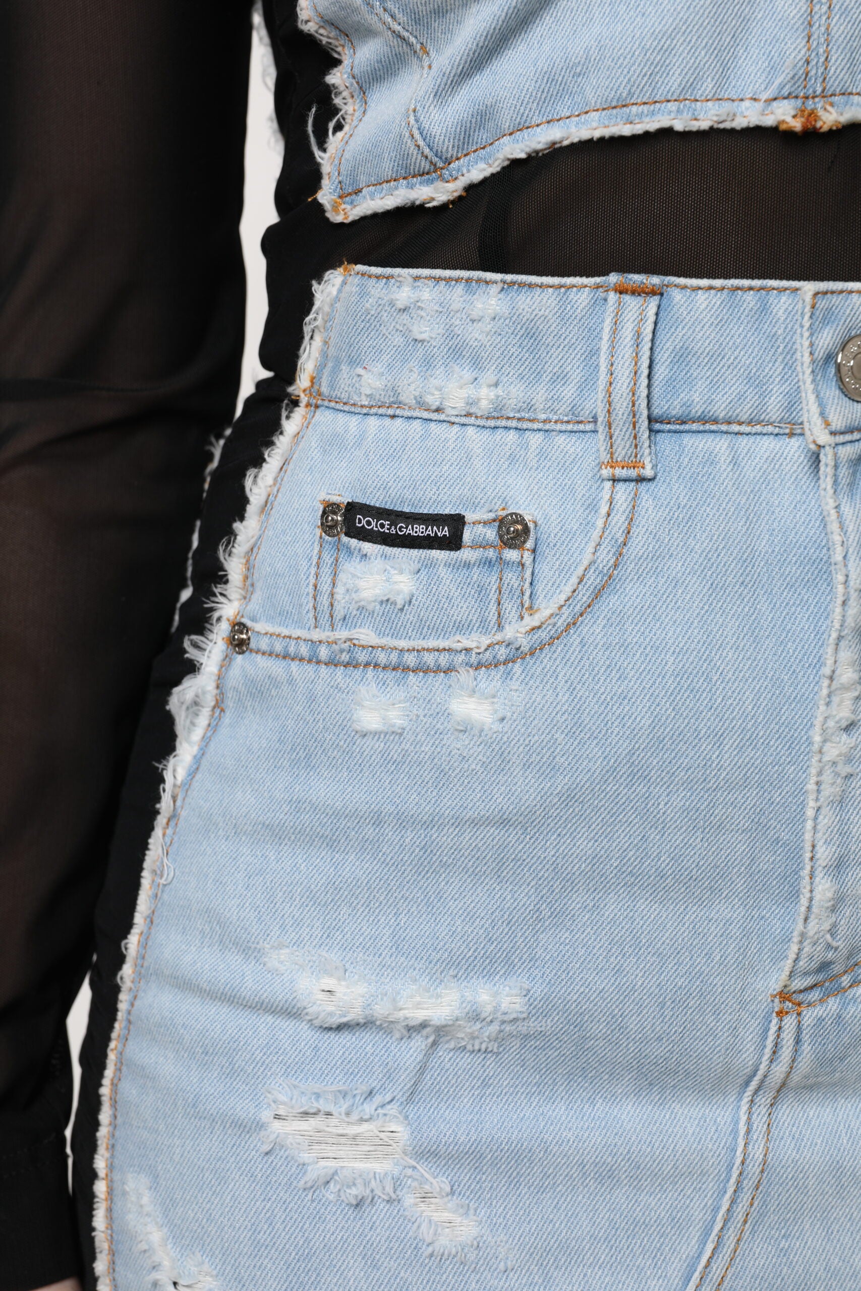 A pair of blue denim jeans with distressed details and a black belt