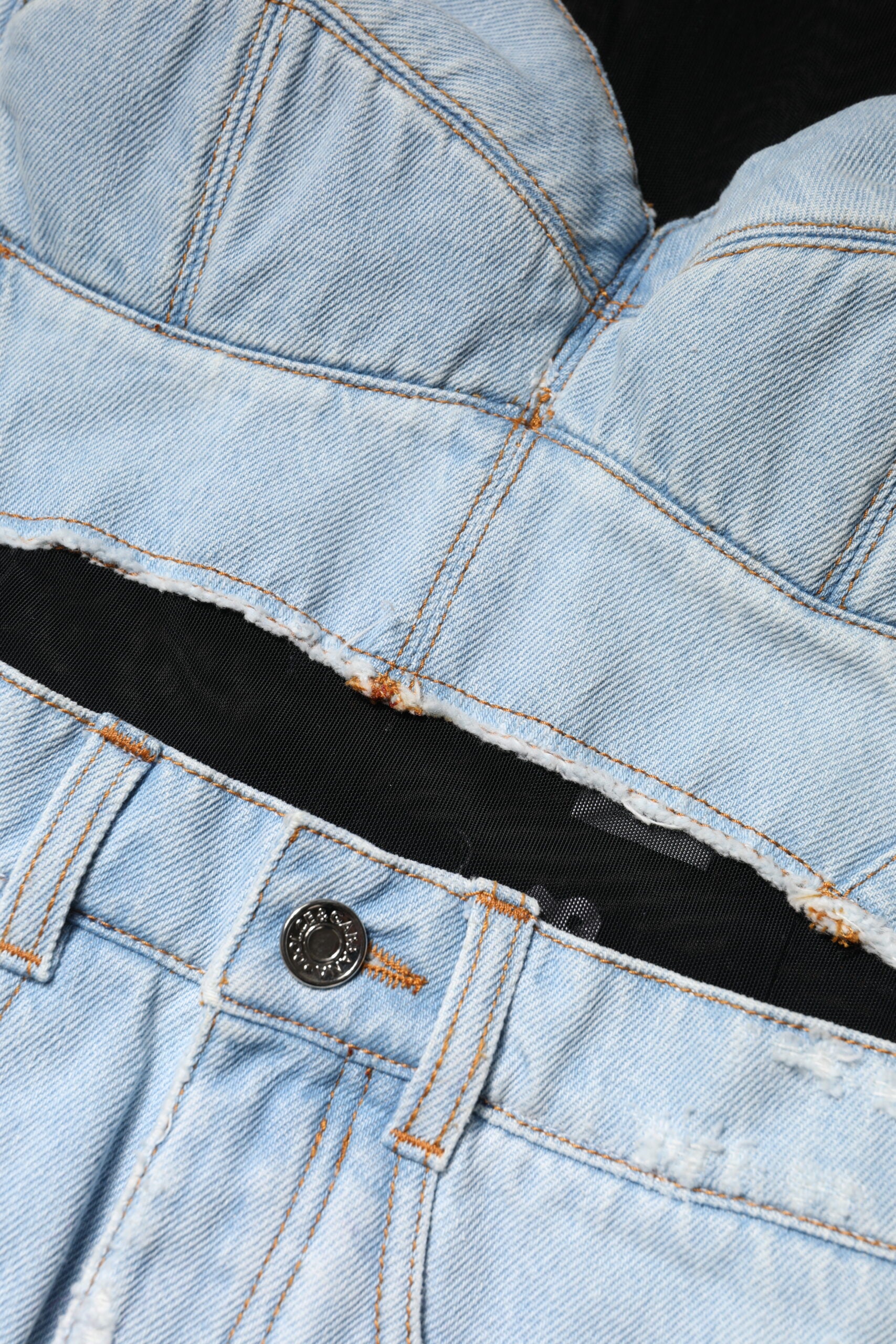 A pair of blue denim jeans with a black belt and button