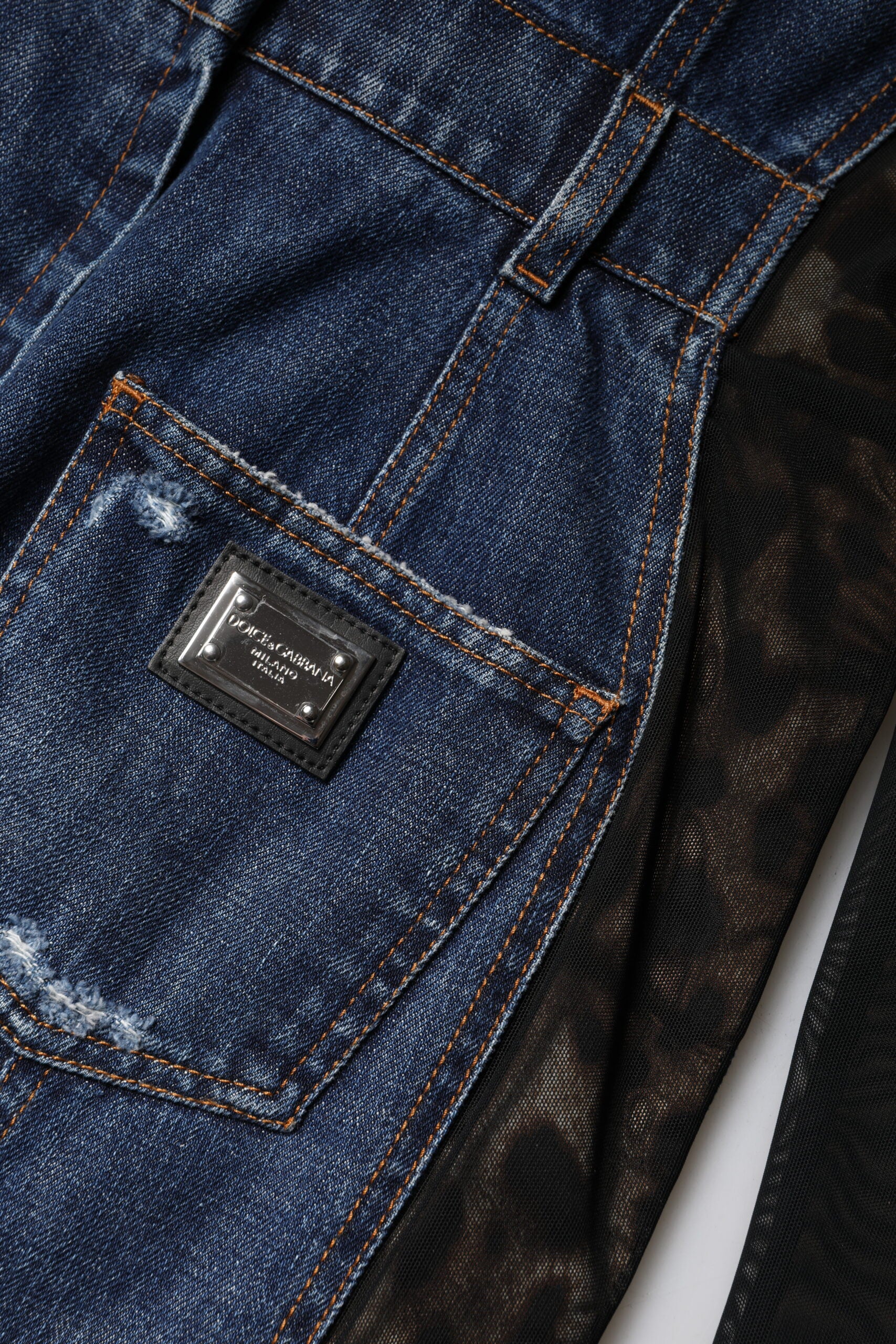 A pair of blue denim jeans with a black label on the front right leg