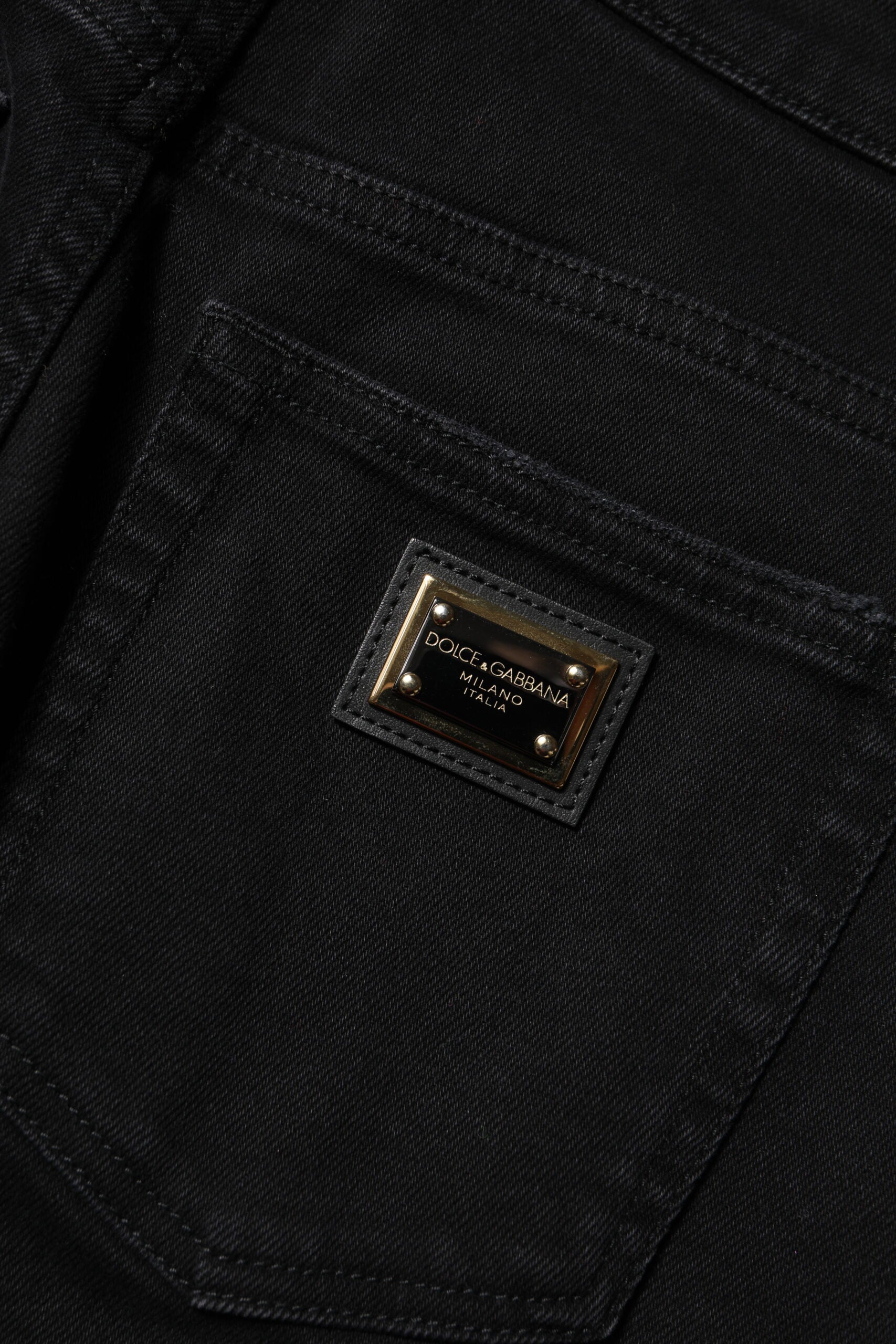 A pair of jeans with a branded label on the right side of the waistband