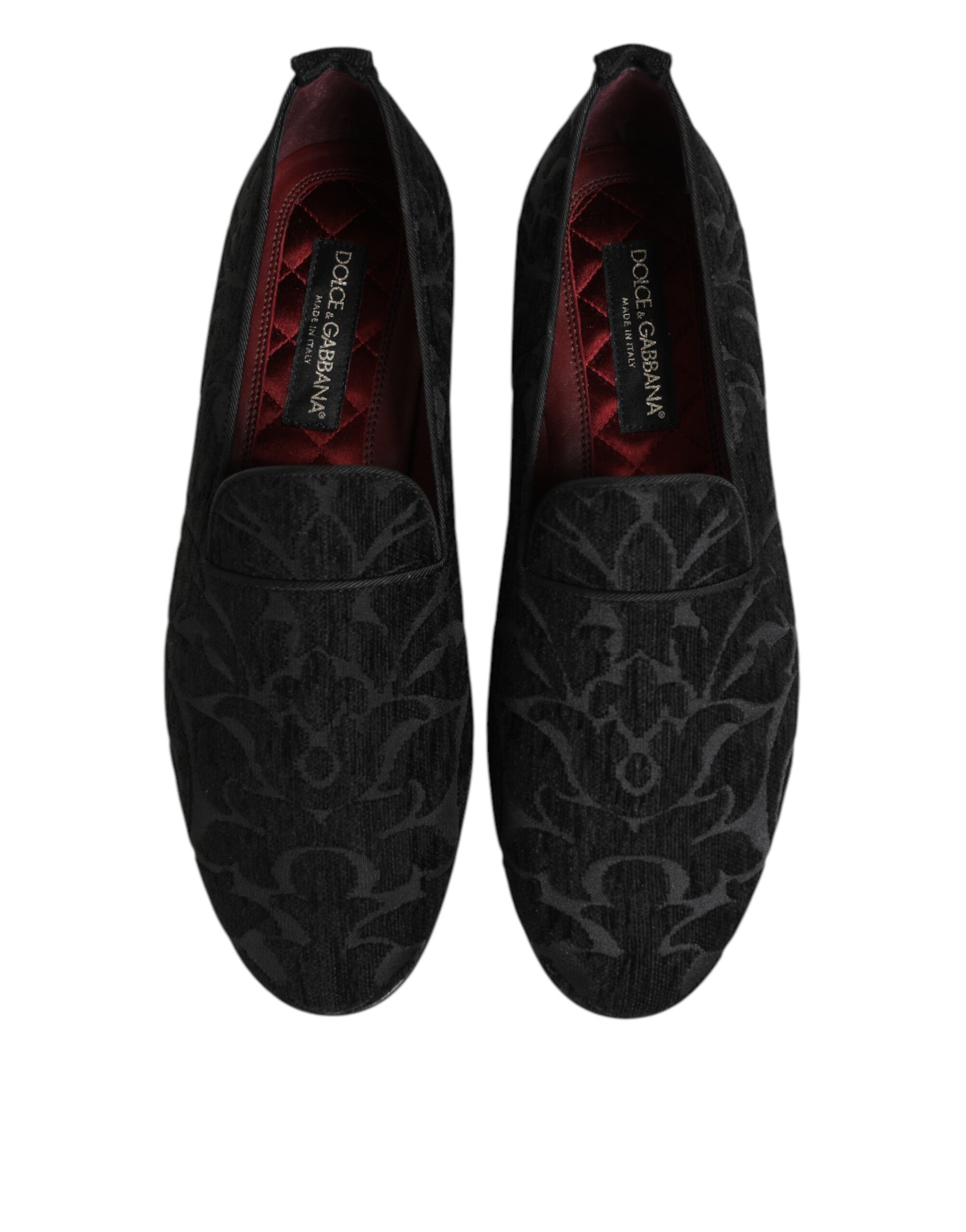 Pair of black brocade loafers with red accents, featuring a slip-on design and embossed branding