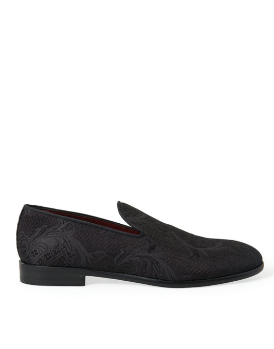 Pair of black loafers with red accents and patterned design on soles