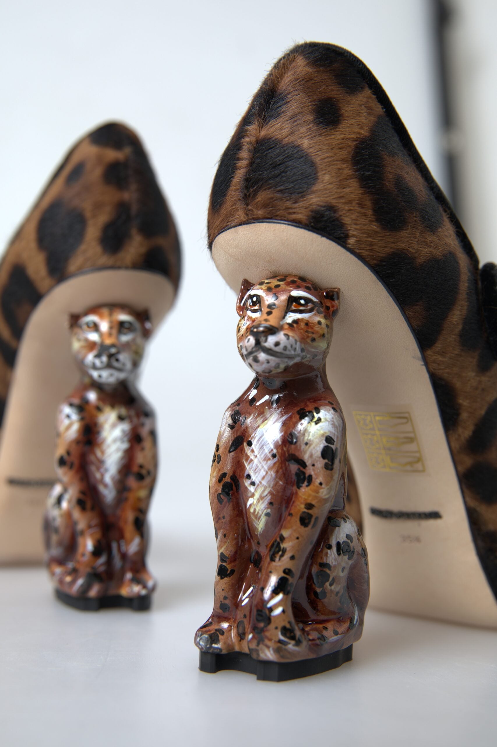 Two cat figurines wearing high heels