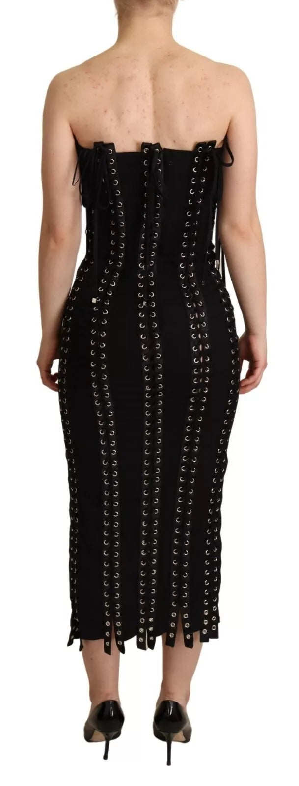 A black cady dress with lace up detailing and a body-skimming silhouette