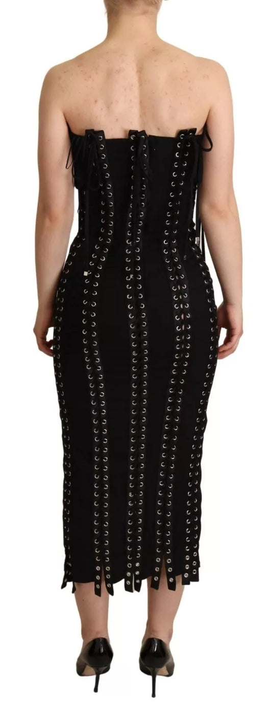 A black cady dress with lace up detailing and a body-skimming silhouette