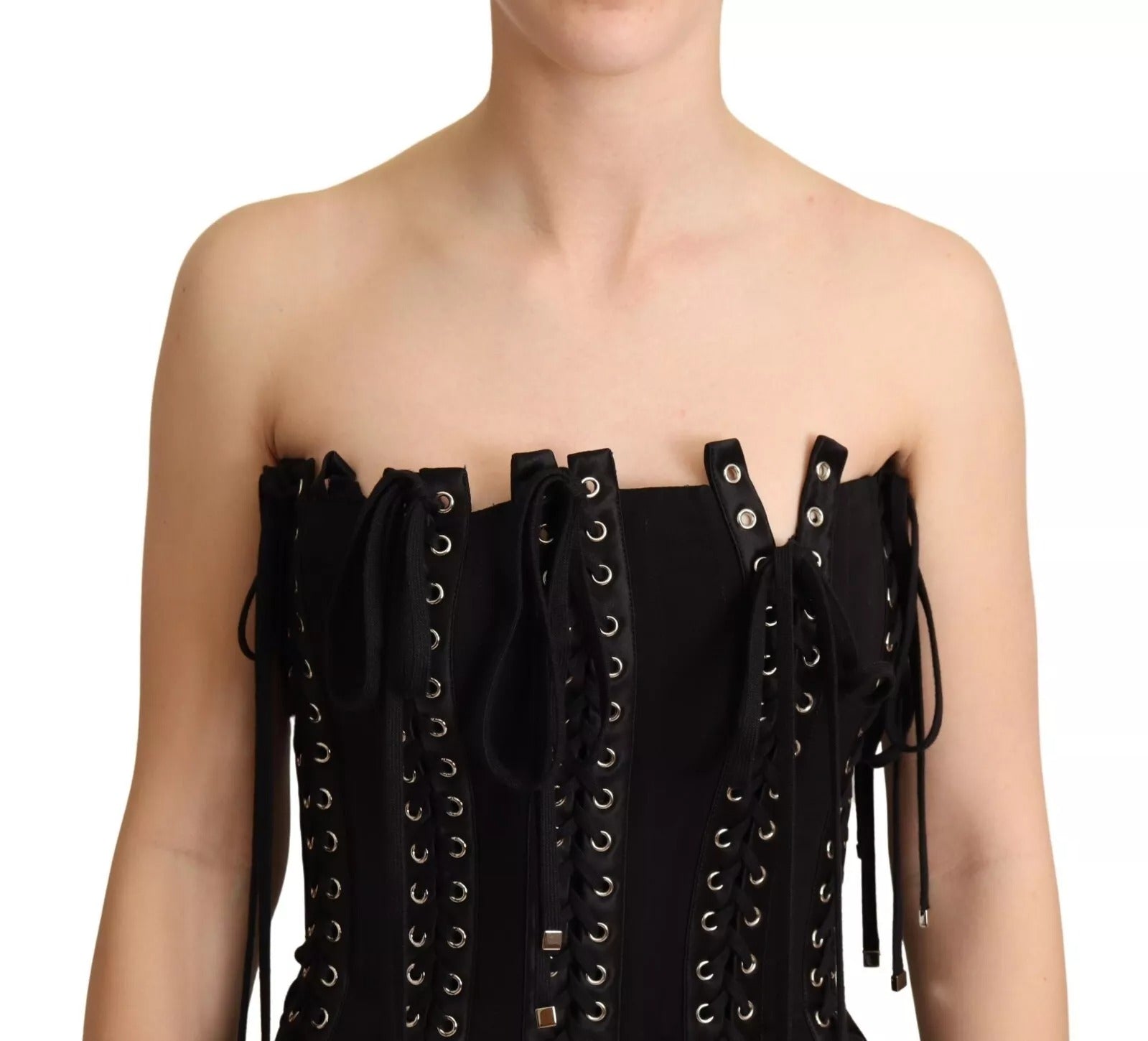 A black cady dress with lace up detailing and fringe trim