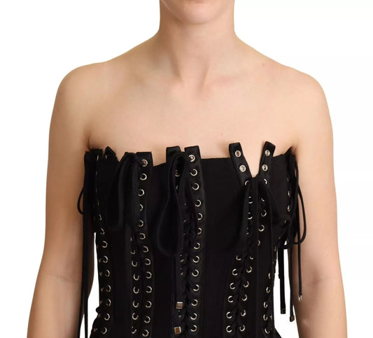 A black cady dress with lace up detailing and fringe trim