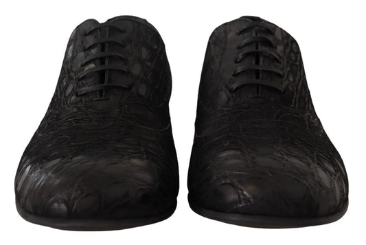 Pair of black patent leather dress shoes with laces and a bow tie design on top