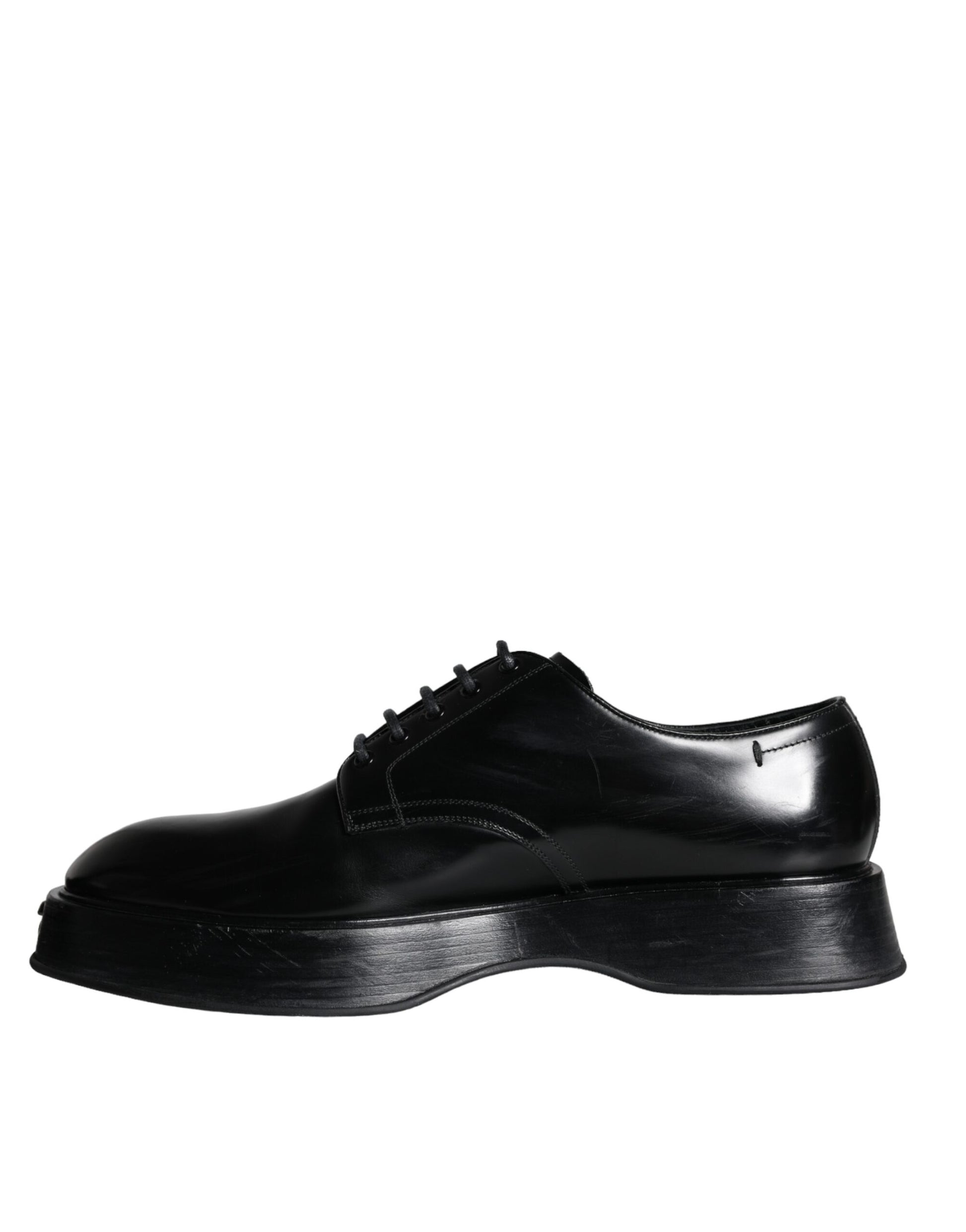A pair of black leather dress shoes with laces and a strap across the top