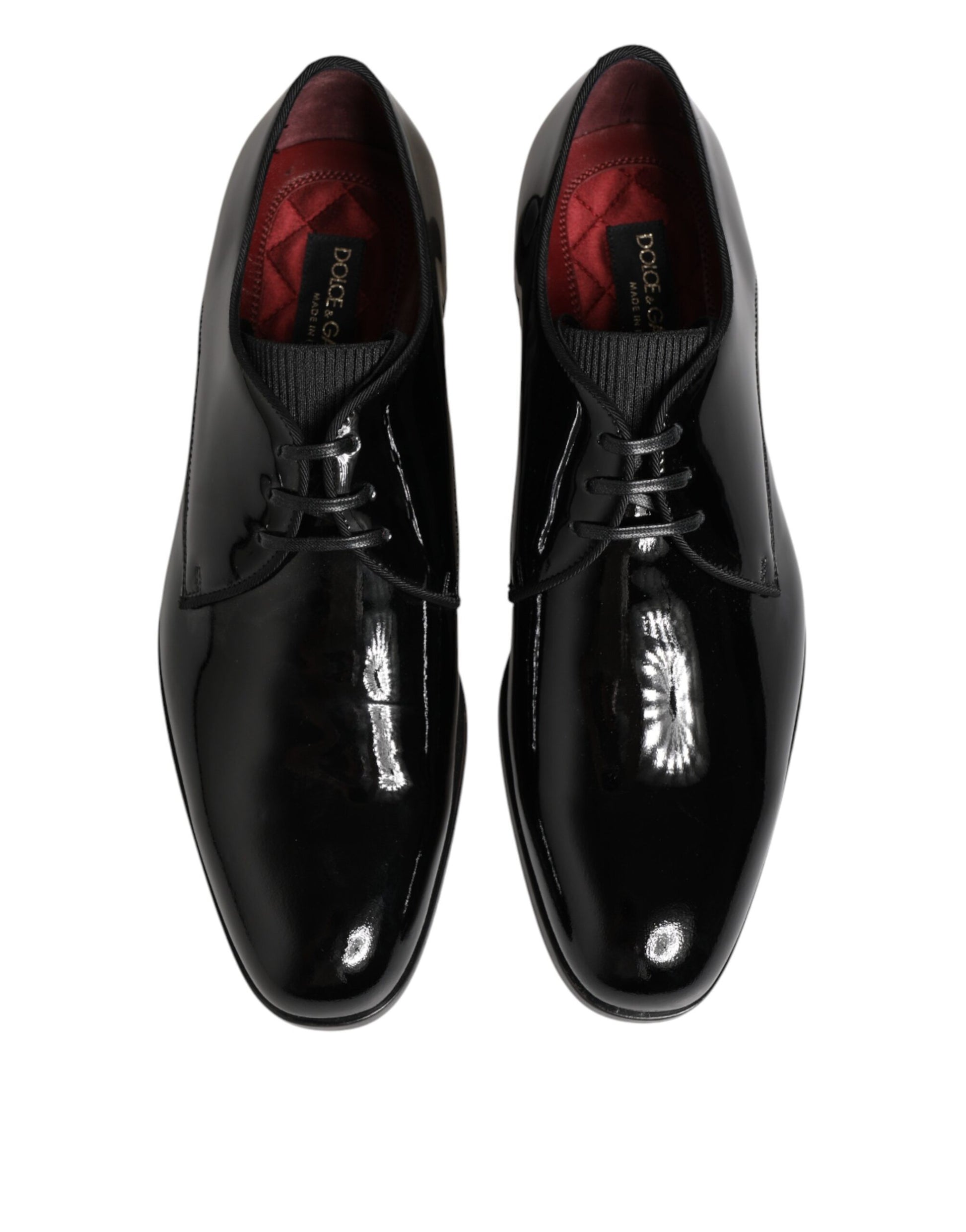 Pair of black leather dress shoes with red laces and a shiny toe cap