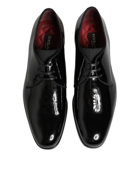 Pair of black leather dress shoes with red laces and a shiny toe cap