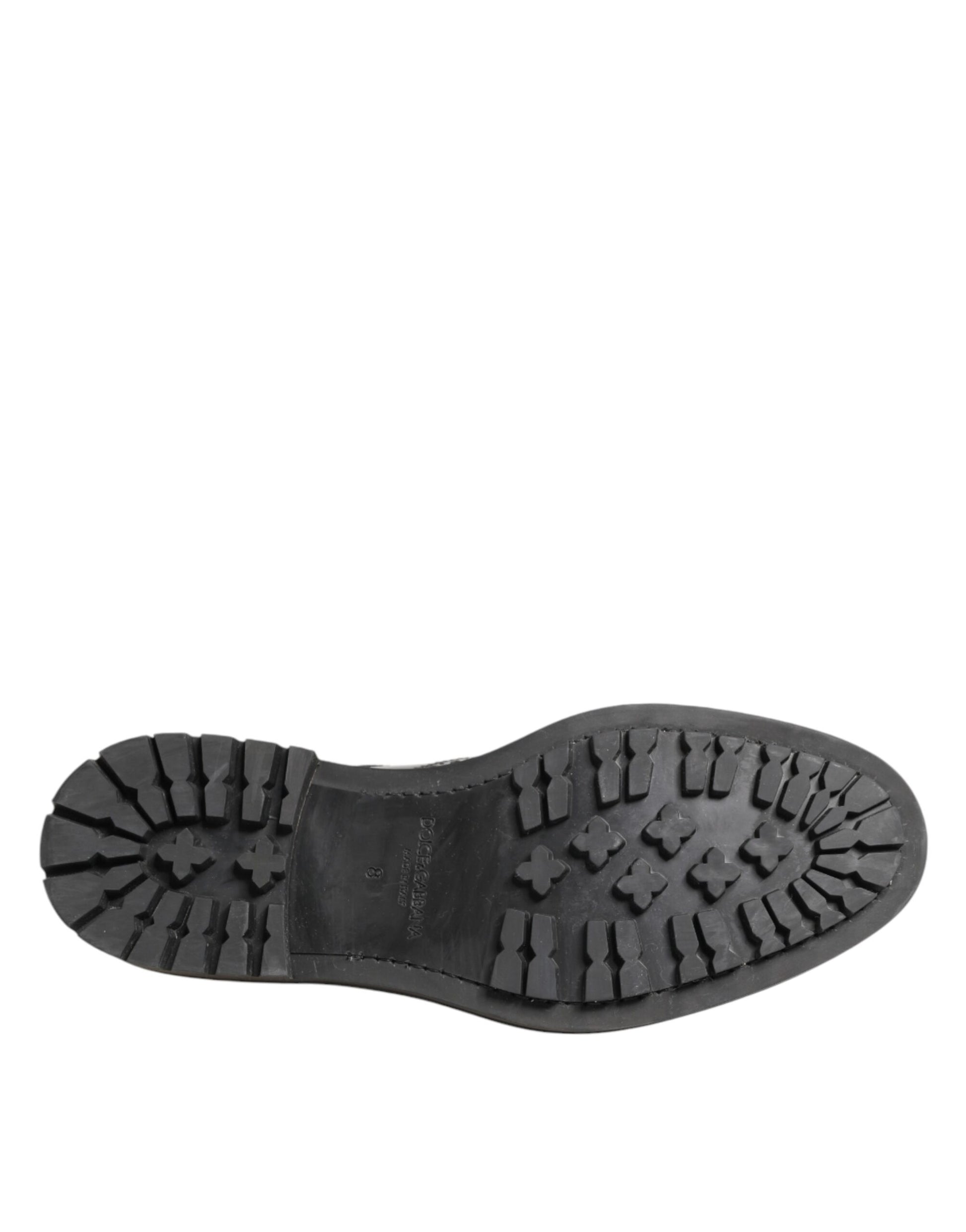 A single black leather shoe with a treaded sole, designed for men and featuring the brand name "Dolce & Gabbana" on the side