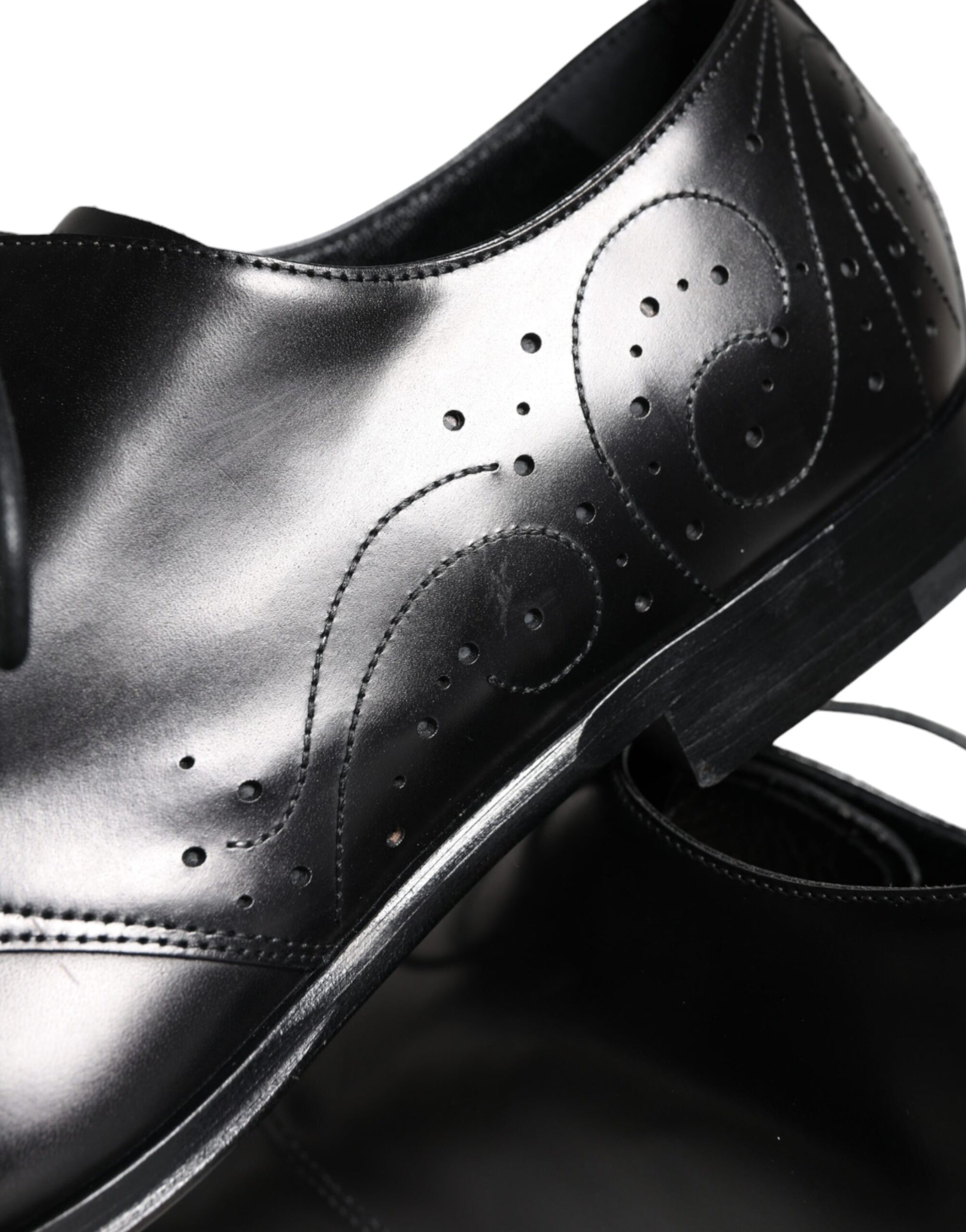 A pair of black leather dress shoes with a lace-up front and embossed design on the side