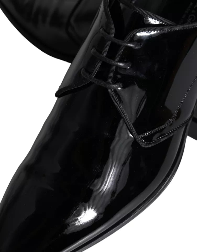 A pair of black leather dress shoes with laces and a shiny finish