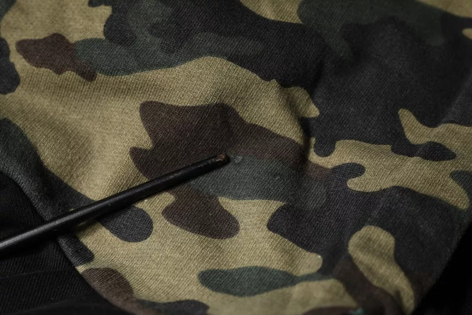 Camouflage fabric with a black needle in it