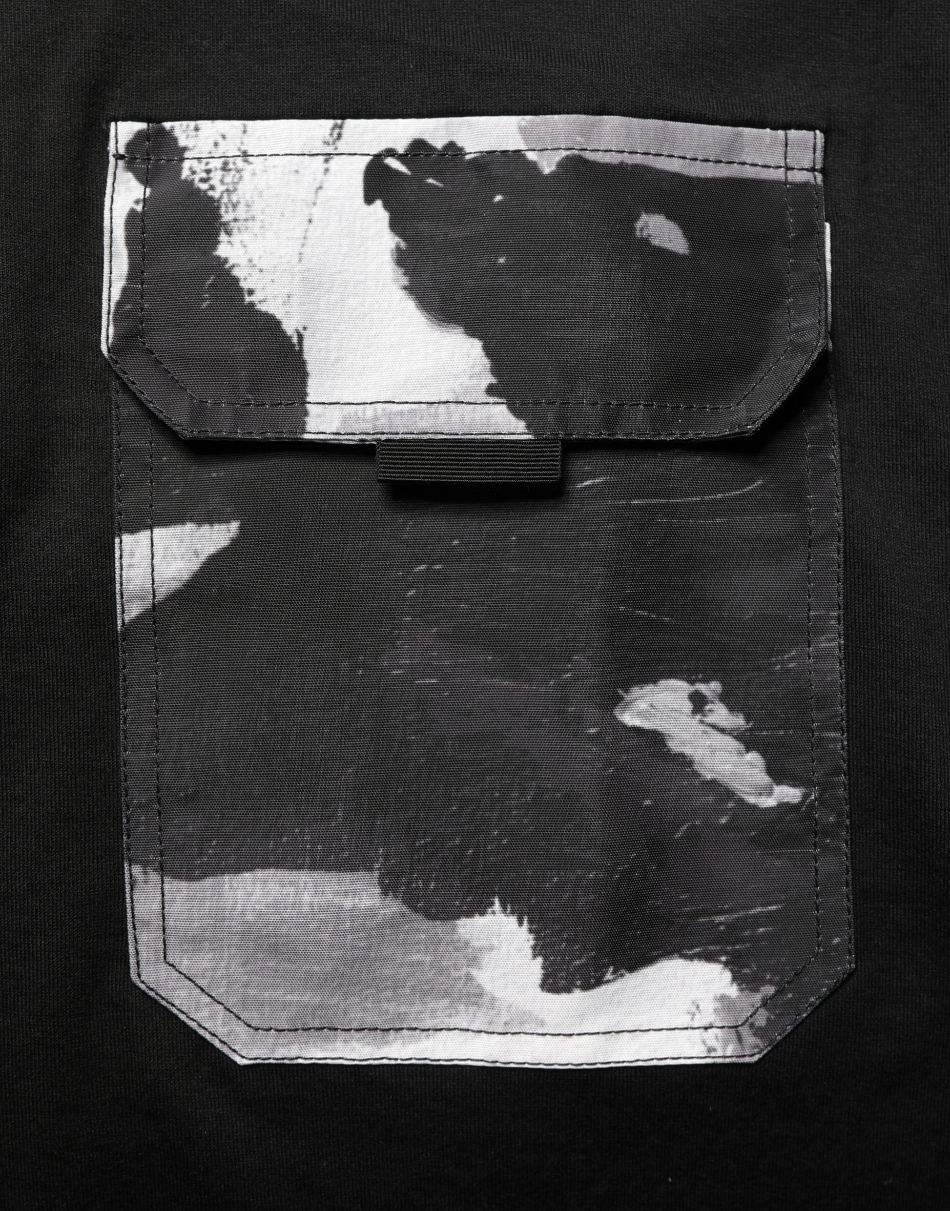 A black camouflage pocket oversized t-shirt with a white splatter design