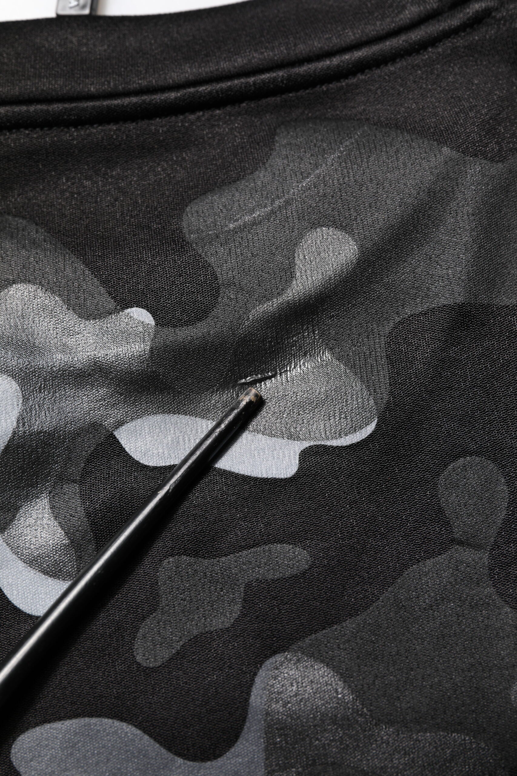 Black t-shirt with camouflage pattern and a brush on top