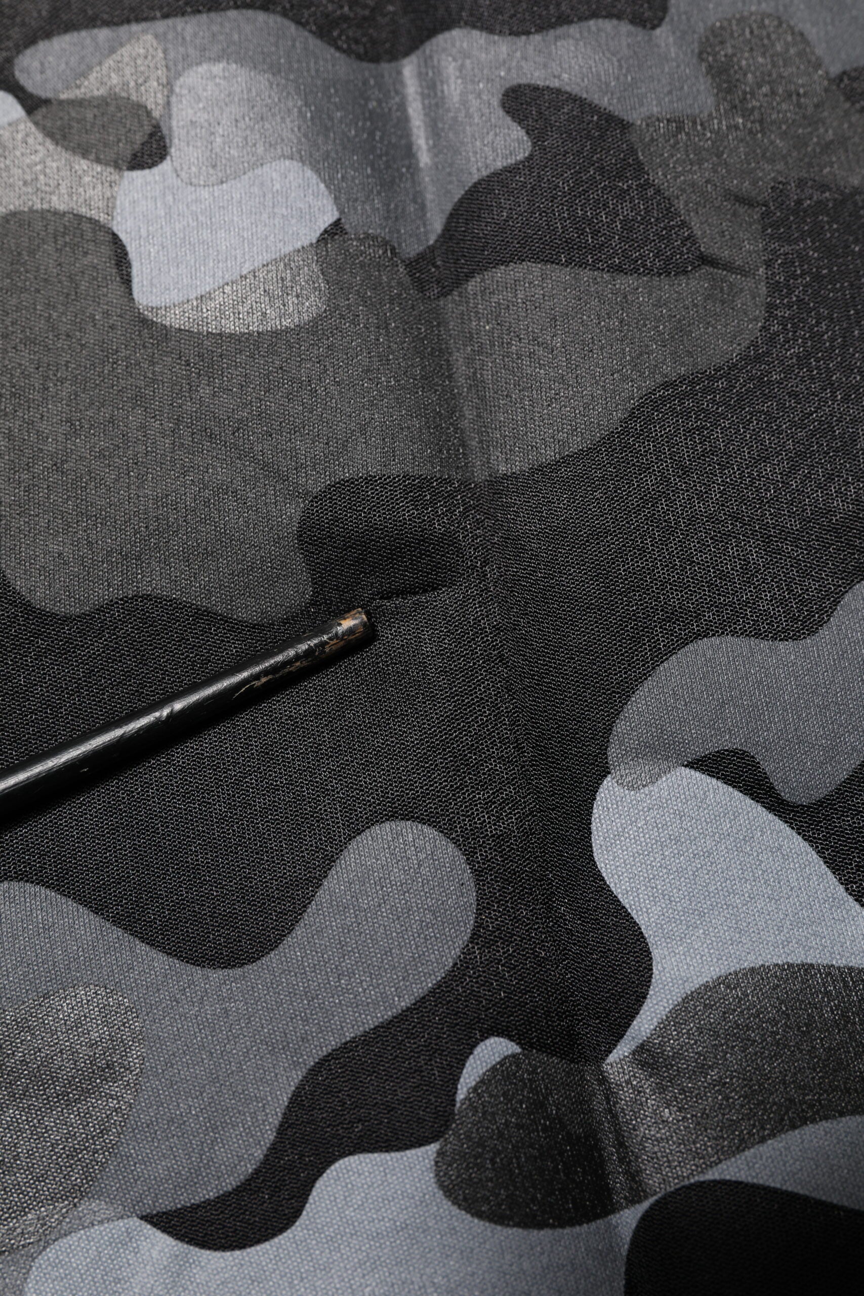 Camouflage fabric with a black pen on top