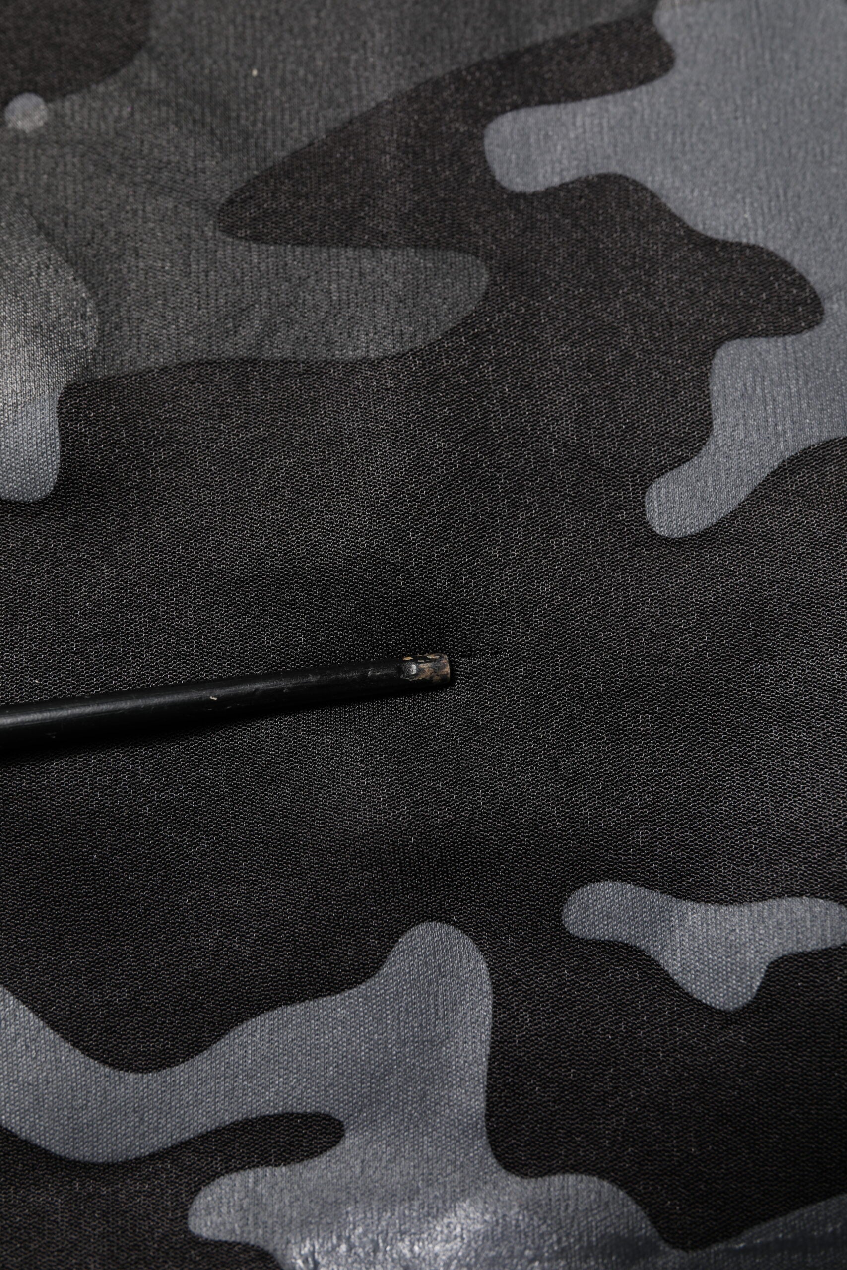 Black pen on camouflage fabric