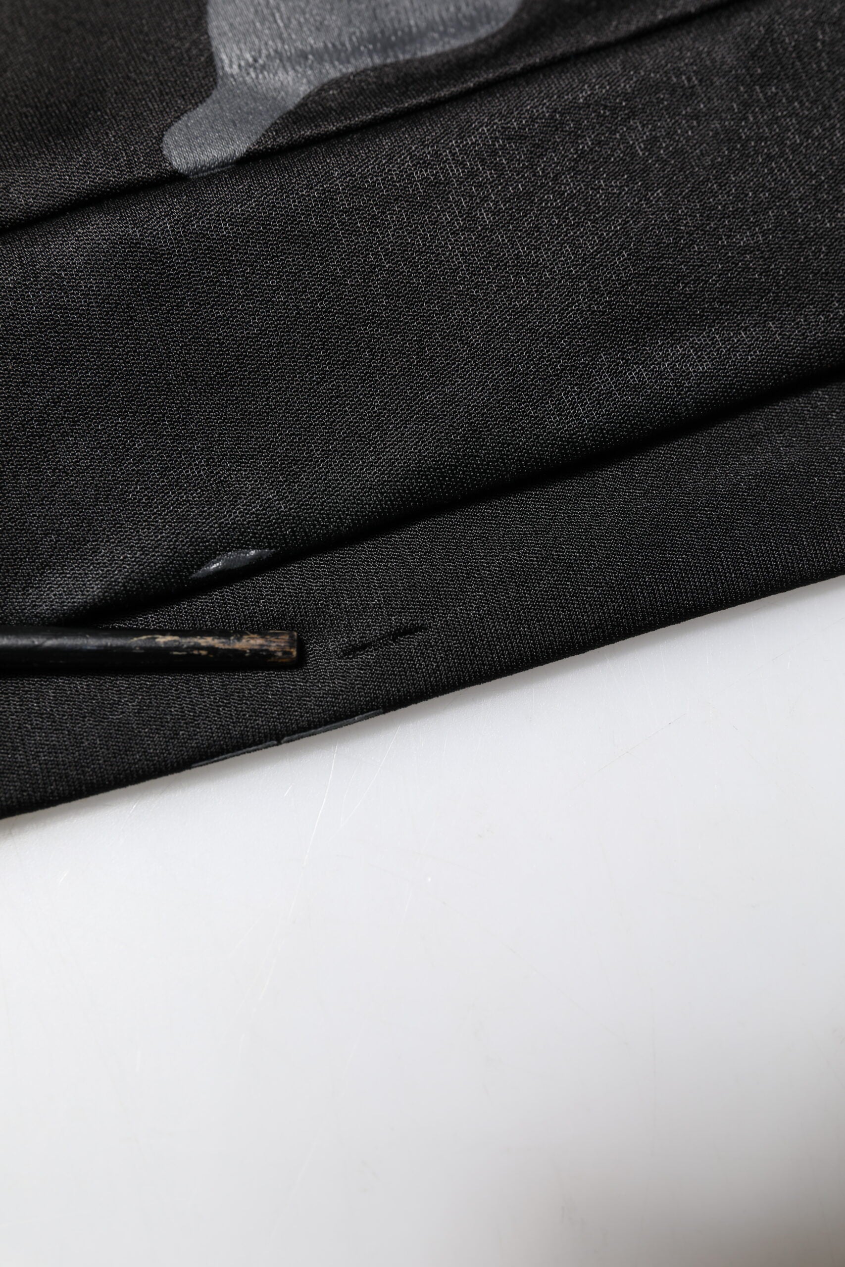 Black fabric with a small hole in it
