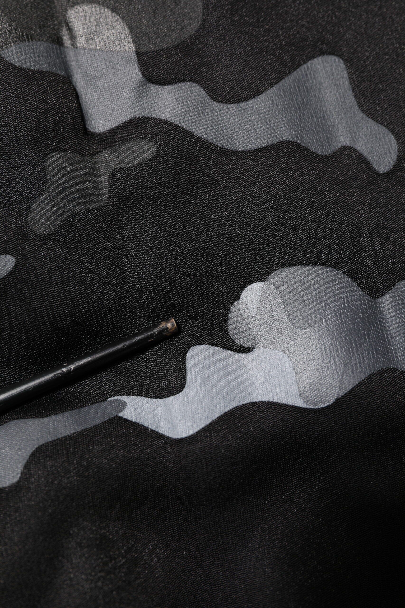 Black fabric with white camouflage pattern