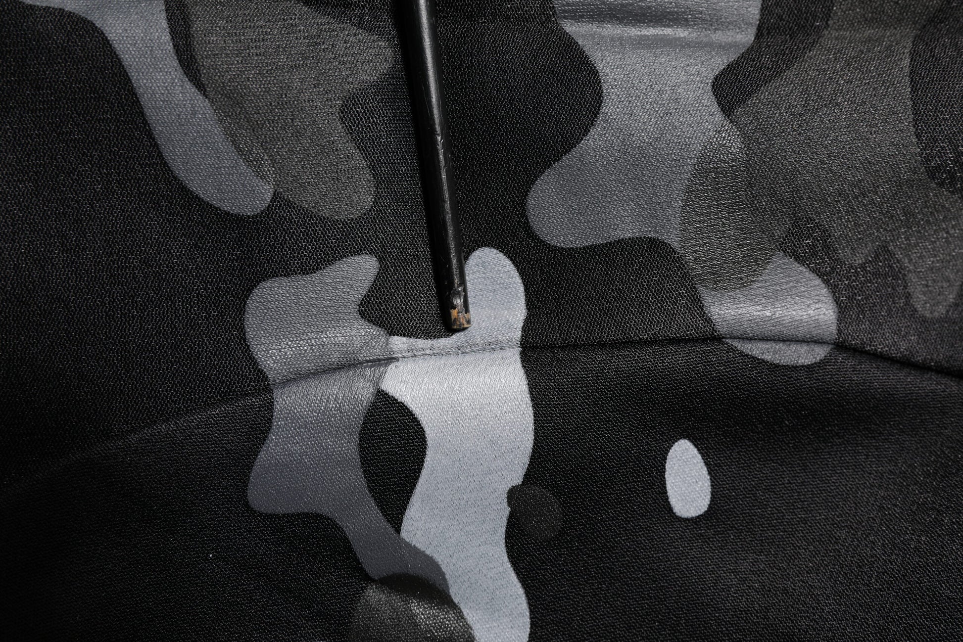 Black fabric with white camouflage pattern
