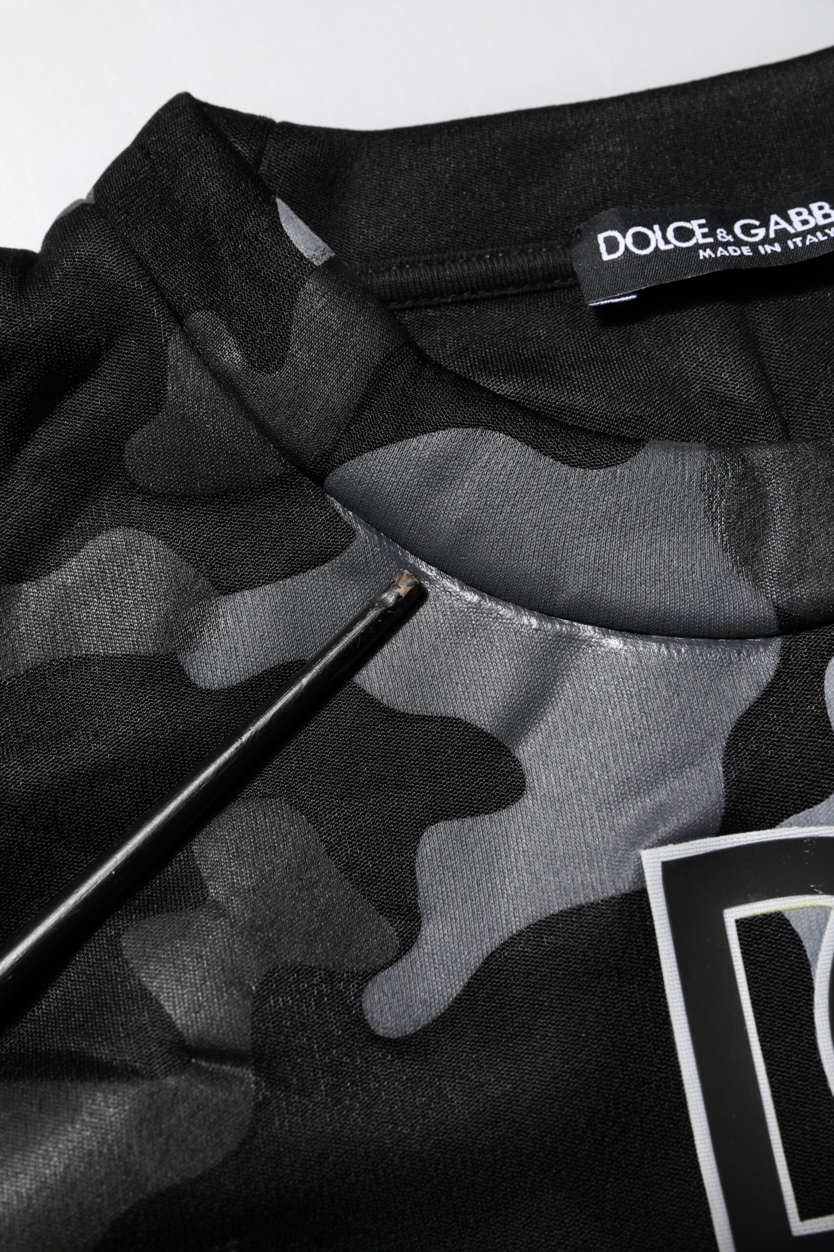 Black camouflage patterned shirt with a tag on it